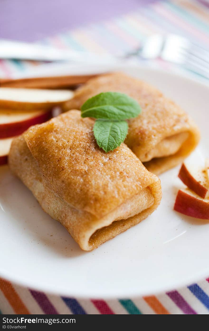 Apple and cinnamon pancakes on a white plate. Apple and cinnamon pancakes on a white plate