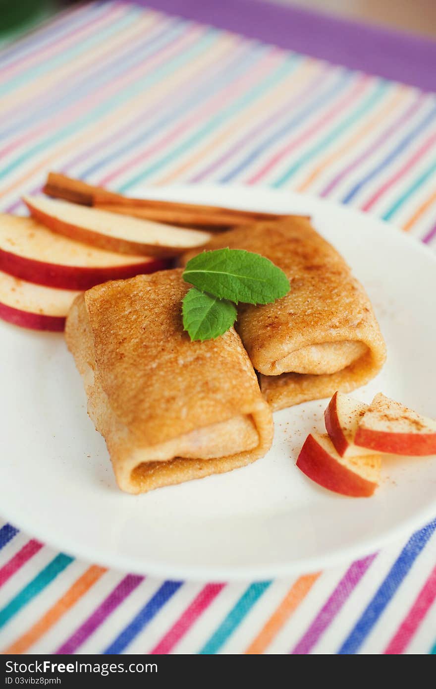 Apple and cinnamon pancakes on a white plate