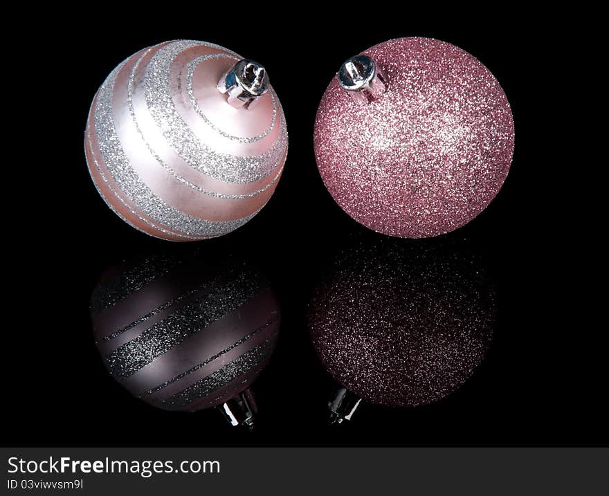 Two purple Christmas balls  on a black background. Two purple Christmas balls  on a black background