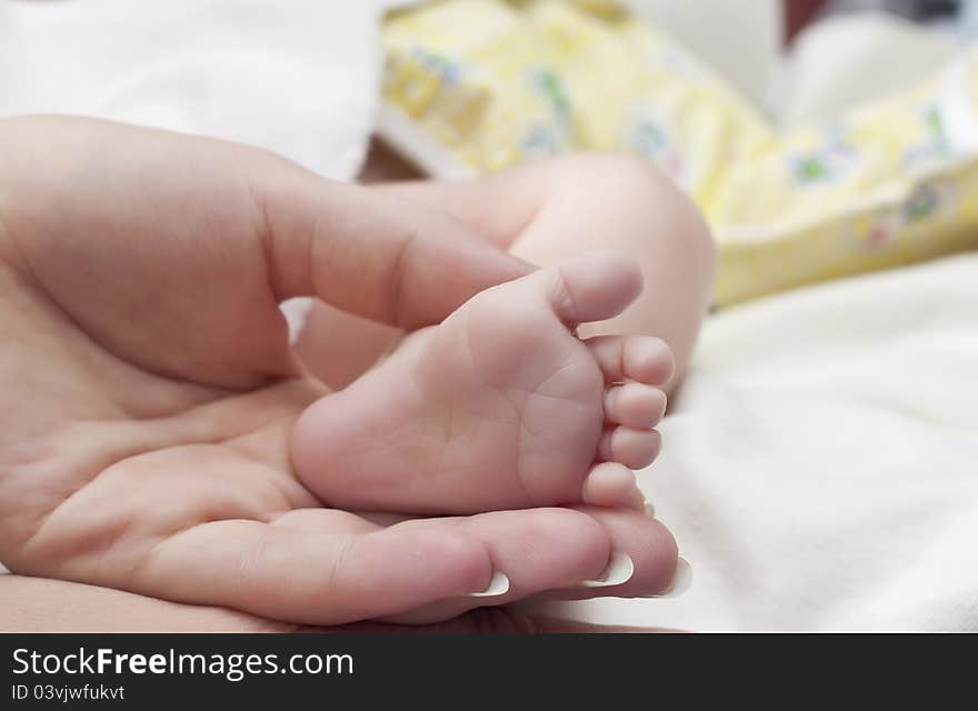 Masseur massaging little baby's foot, shallow focus