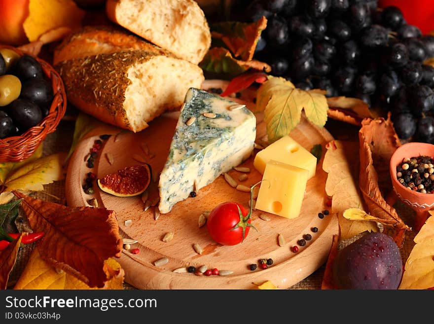 Still life with cheese and autumn fruits