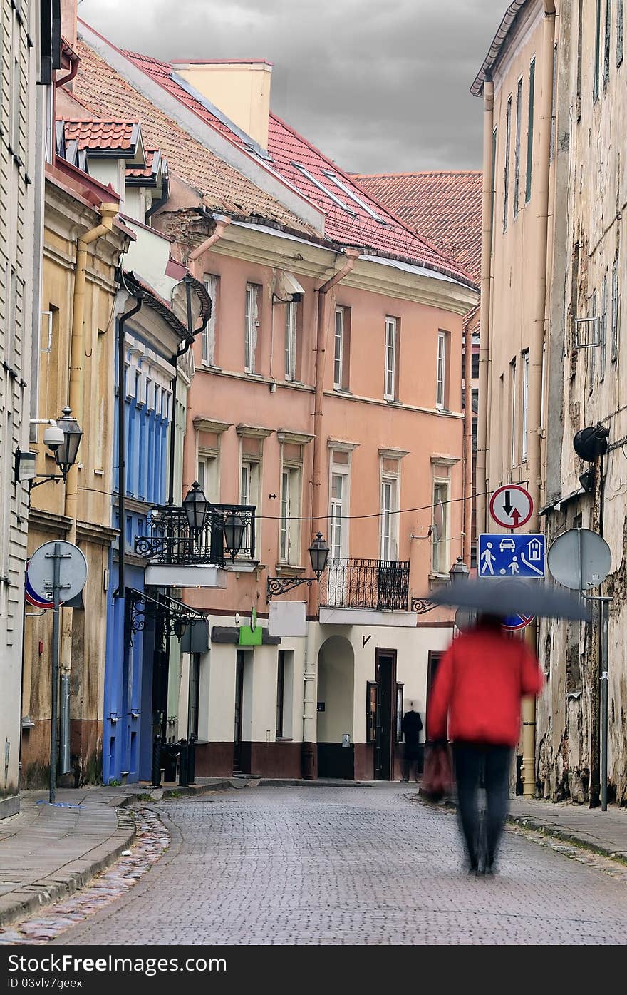 Vilnius oldtown street in a rainy day. Two people - motion blur. Vilnius oldtown street in a rainy day. Two people - motion blur