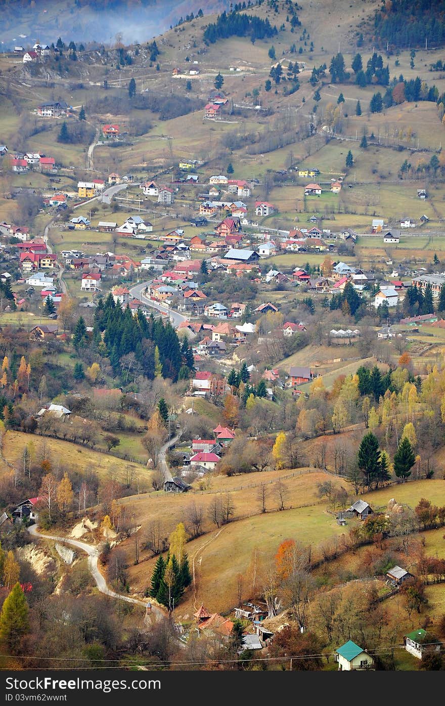 Red roofs village situated in a large valley on Rucar-Bran pass in Romanian Carpathian mountains. Red roofs village situated in a large valley on Rucar-Bran pass in Romanian Carpathian mountains