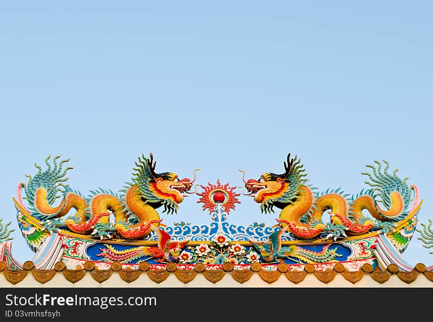 Twin dragon on the roof of shrine with blue sky background