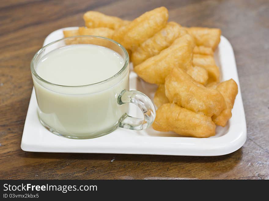 Deep fried dough sticks and a cup of soybean milk on tray