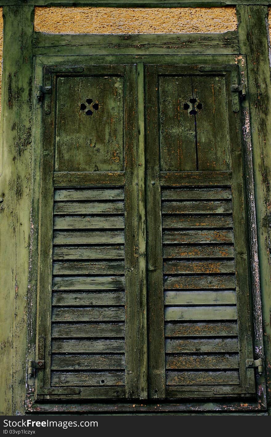 A pair of very old wooden shutters painted green yet dilapidated. Very good wood and decay textures. A pair of very old wooden shutters painted green yet dilapidated. Very good wood and decay textures.