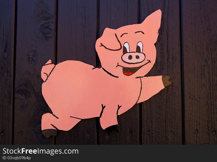 Cartoon wooden painted Pink Pig on black background