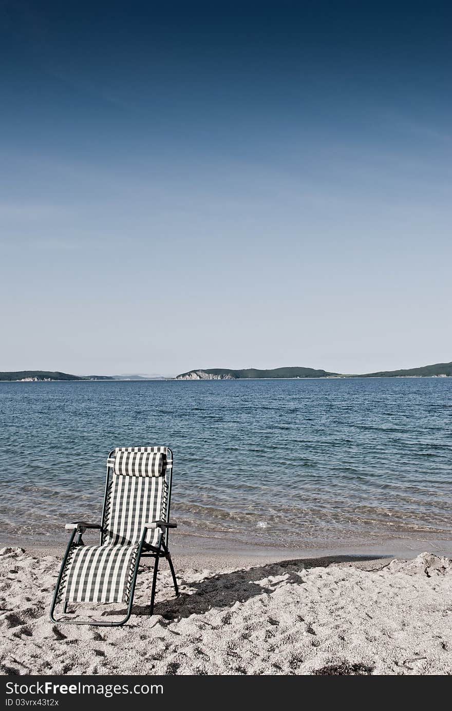 Beach seat on a shore with sand and blue sky