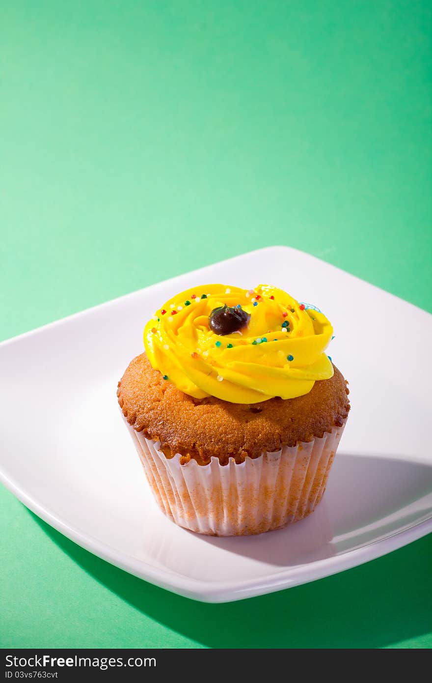 Delicious cupcake on green background.