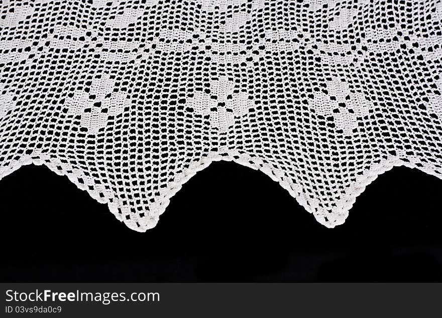 White lace forms a delicate border against black background. White lace forms a delicate border against black background.