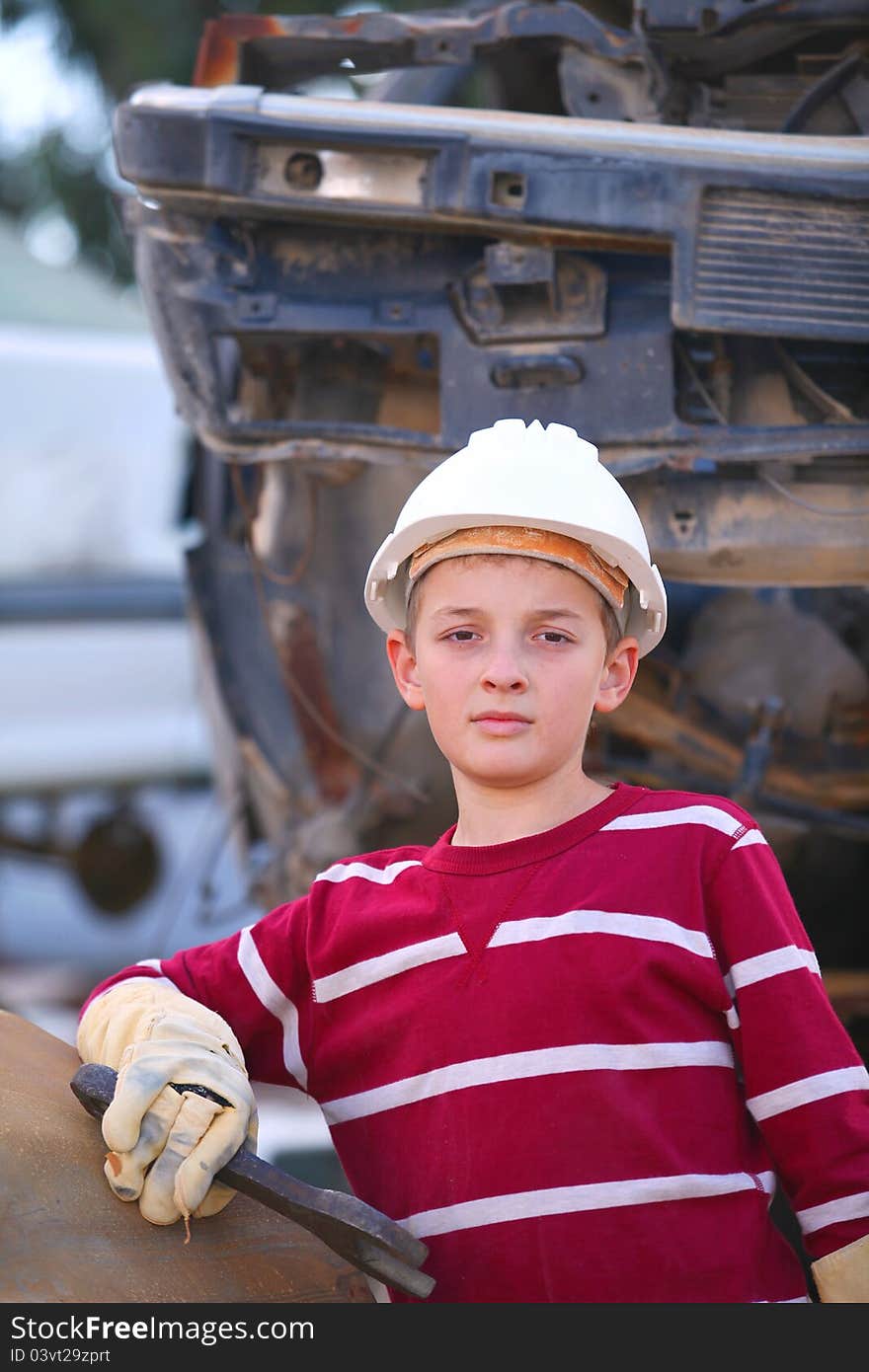 The boy mechanic in a helmet with a key repair