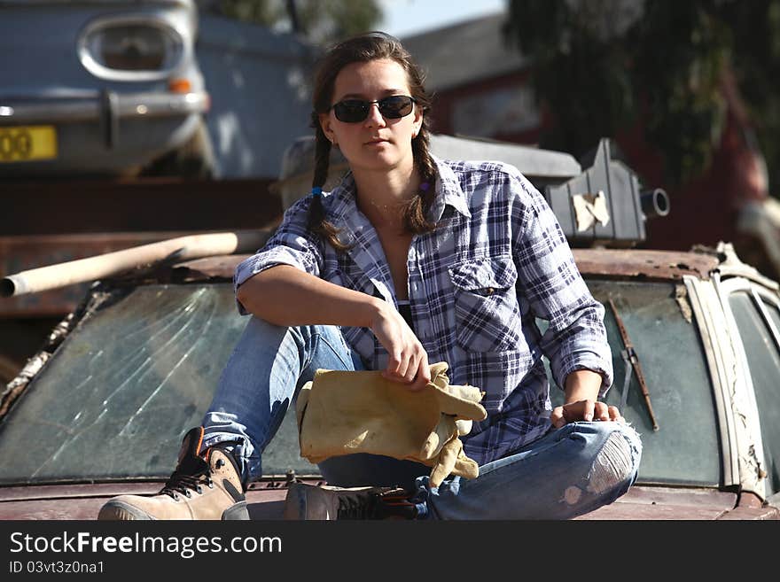 Woman posing in a landfill auto