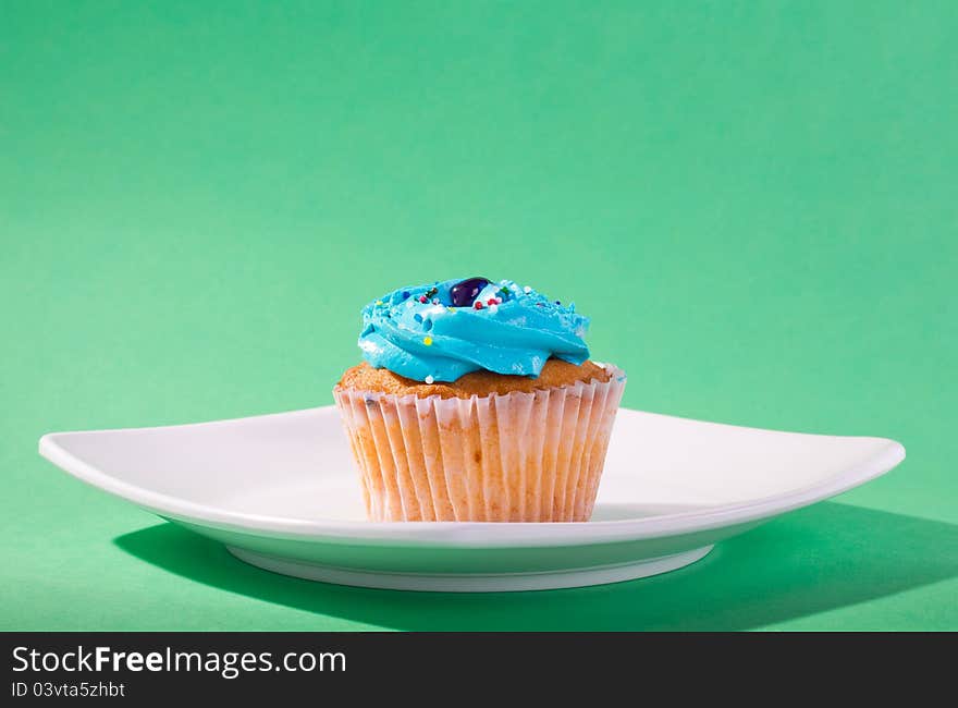 Delicious cupcake on green background.