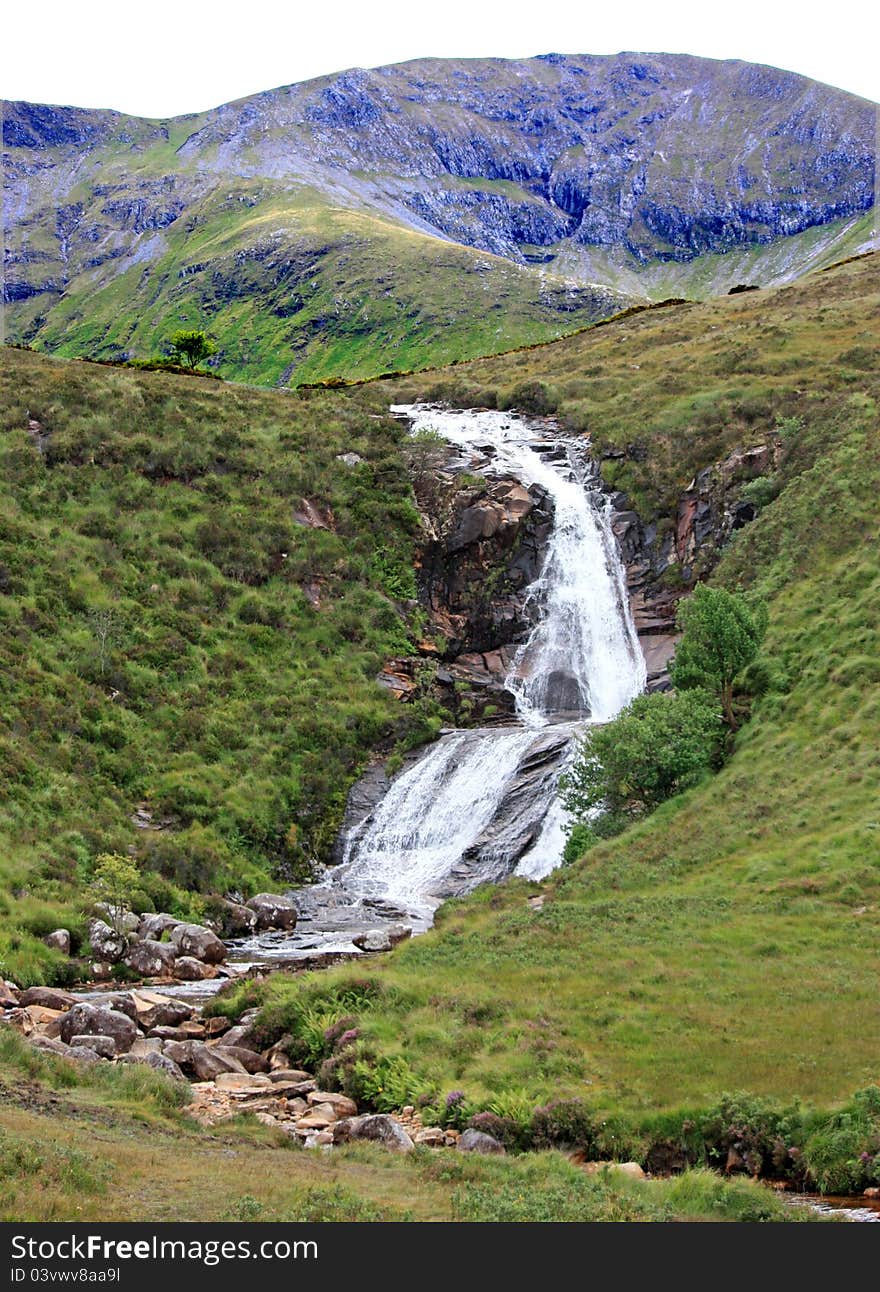 A Waterfall Flowing Over a Rocky Mountainside. A Waterfall Flowing Over a Rocky Mountainside.