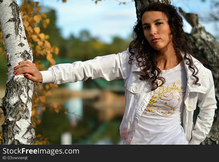 Brunette in autumn forest near