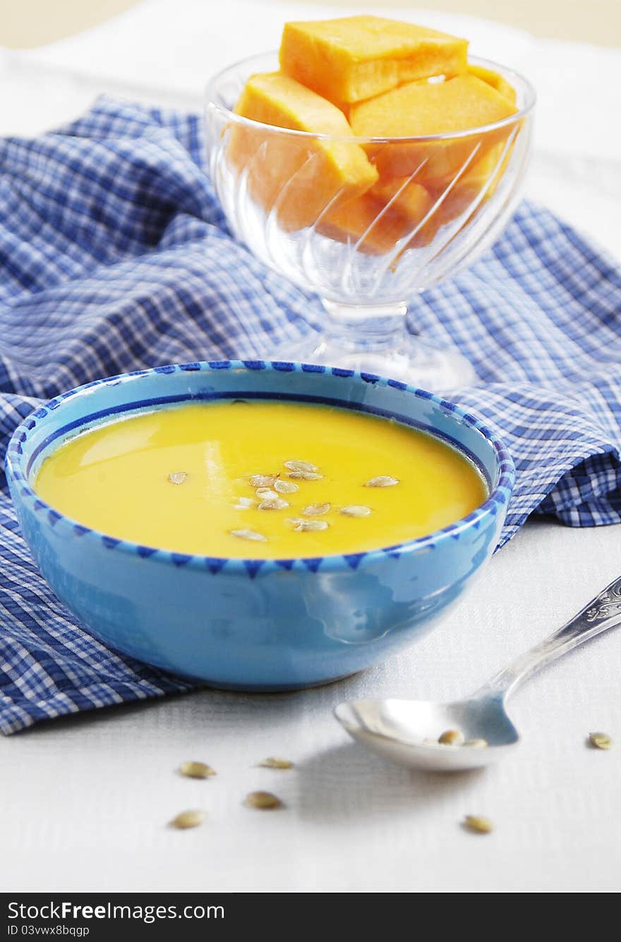 Fresh home-made pumpkin soup with curry in blue bowl