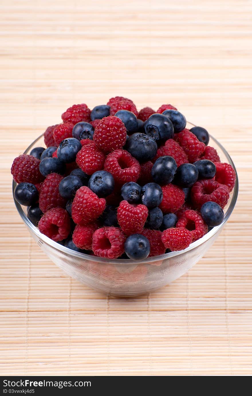 A bowl of fresh raspberries and blueberries. A bowl of fresh raspberries and blueberries