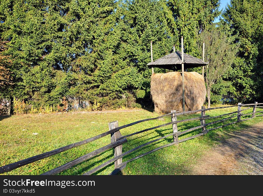 Haycock and old wooden fence in generic transylvania village. Haycock and old wooden fence in generic transylvania village