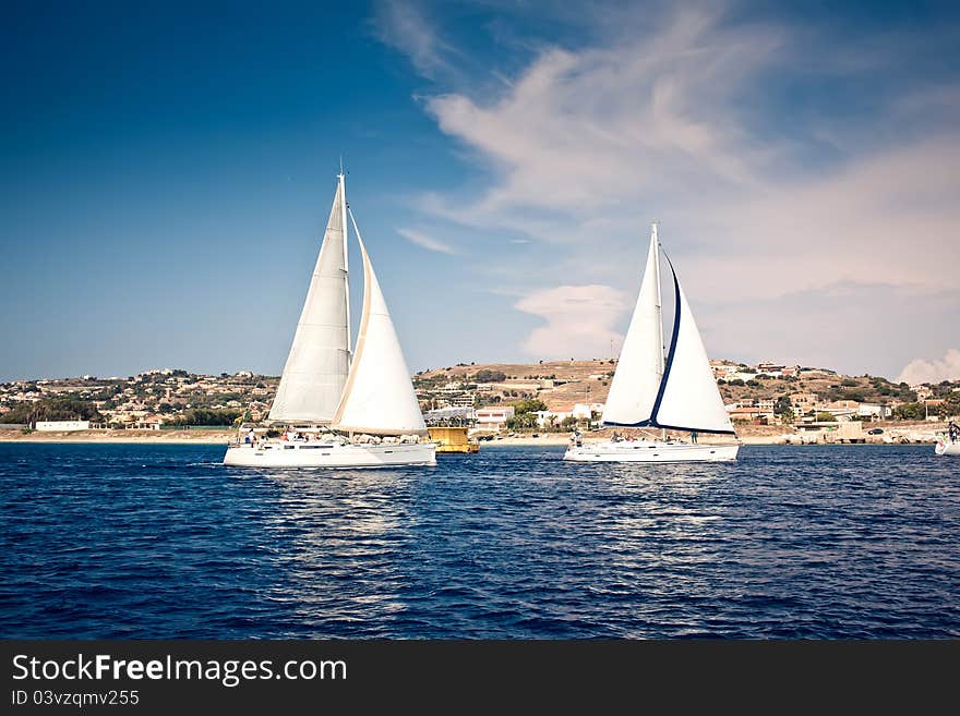 Sailing ship yachts with white sails at the open sea