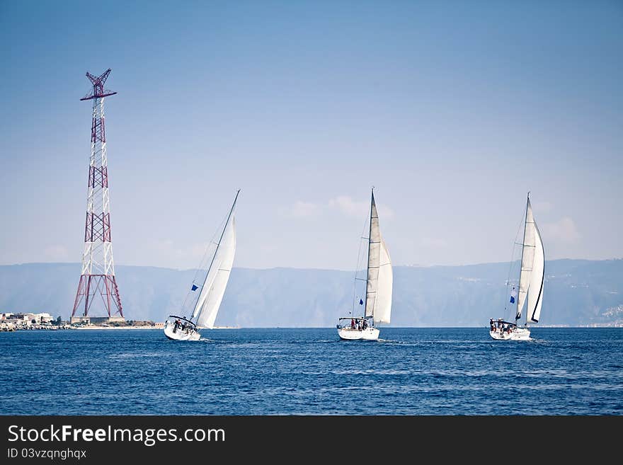 Sailing ship yachts with white sails at the open sea