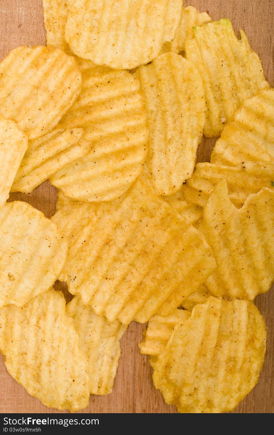 Rippled potato chips over wooden background