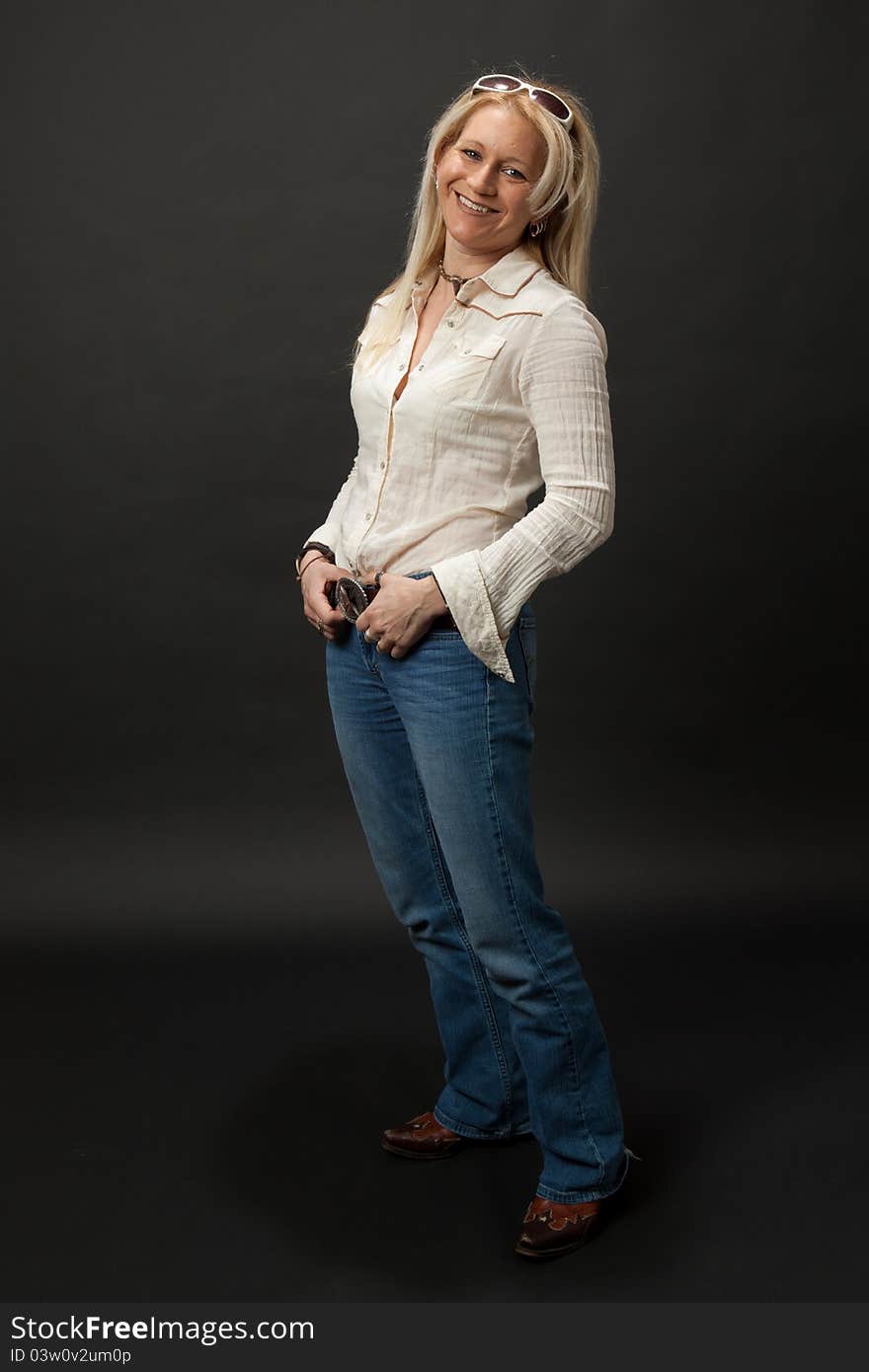 Studio shot of a blonde cowgirl leaning back with a big smile. Studio shot of a blonde cowgirl leaning back with a big smile