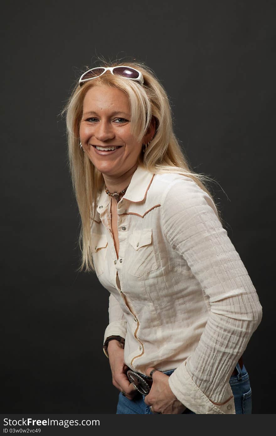 Studio shot of a blonde girl leaning forward with a big smile. Studio shot of a blonde girl leaning forward with a big smile