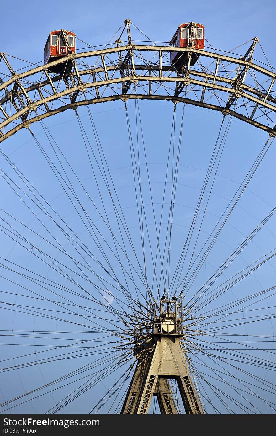 Sunlit ferris wheel of Vienna with little moon in the back. Sunlit ferris wheel of Vienna with little moon in the back