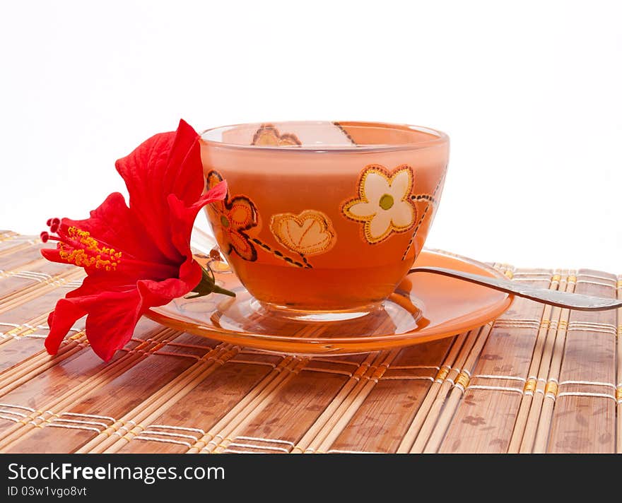 The cup of tea with a flower of hibiscus