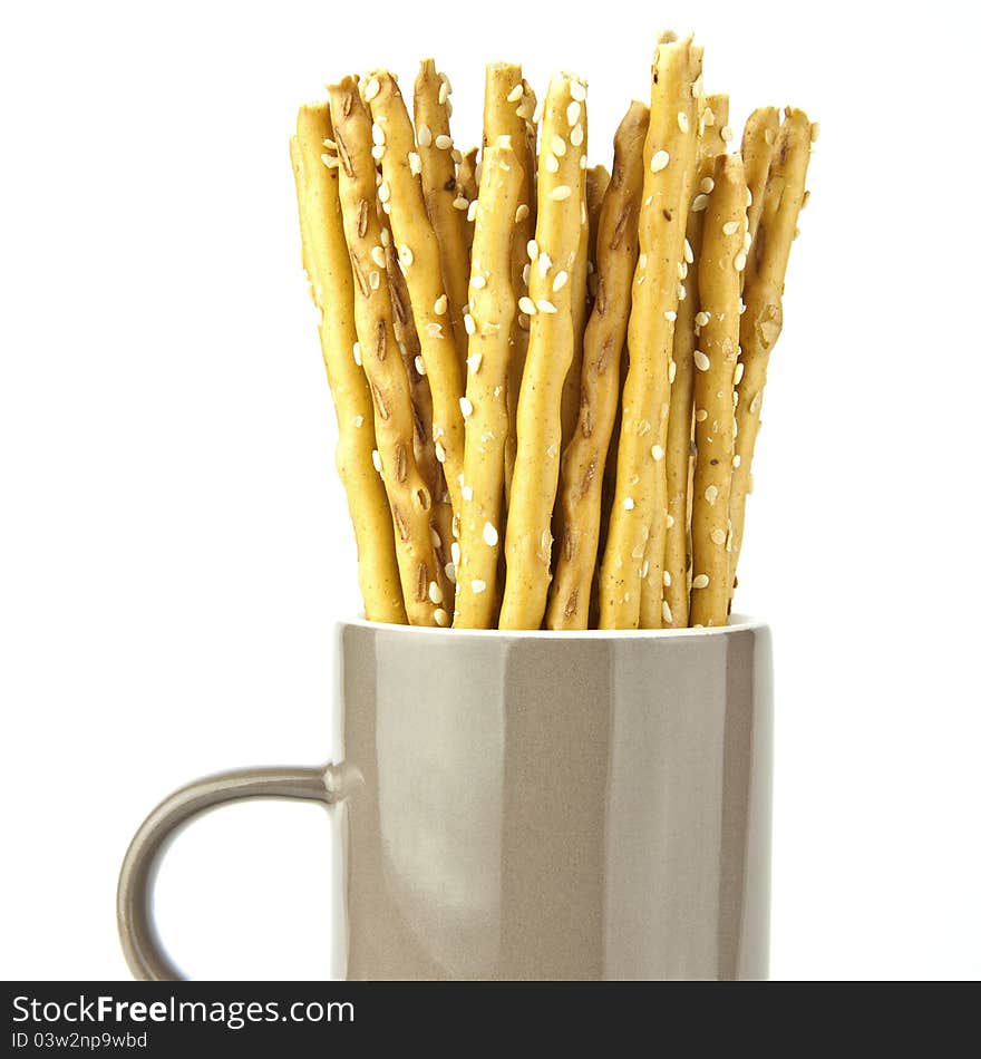 Crispy bread sticks put in mug isolated on white