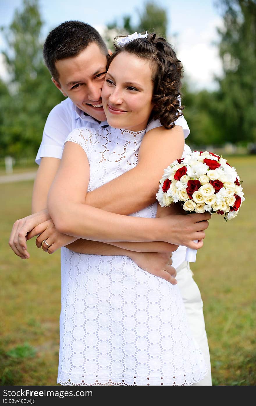 Portrait of a happy couple embracing eachother against a green park