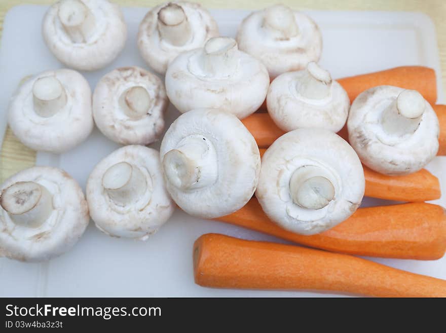 Carrots and mushrooms on the counter ready for cutting