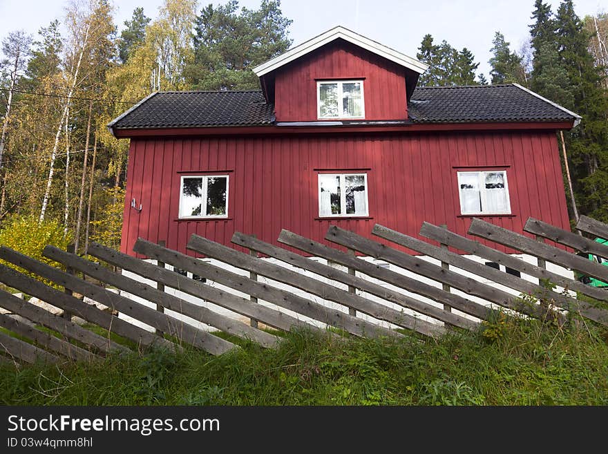 Red summer cottage surrounded by trees in Norway. Red summer cottage surrounded by trees in Norway