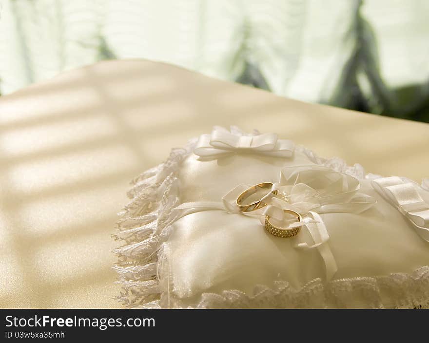 Gold wedding rings on a  pillow