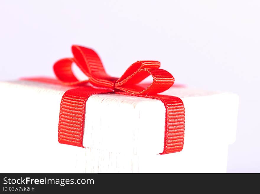 White gift box with red ribbon