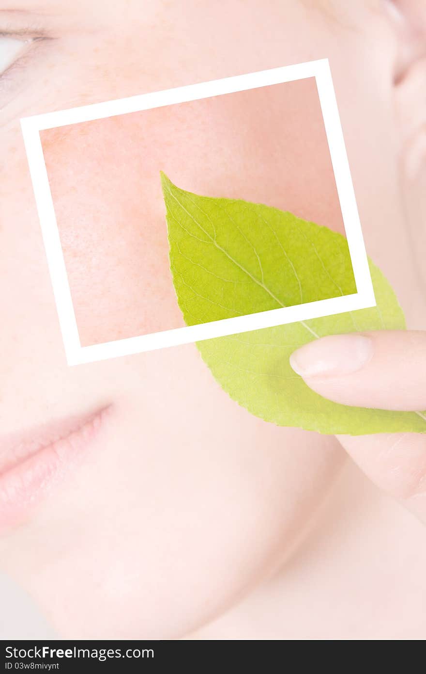 The girl with a leaf of a plant at the person. Closeup. Post-processing. The girl with a leaf of a plant at the person. Closeup. Post-processing