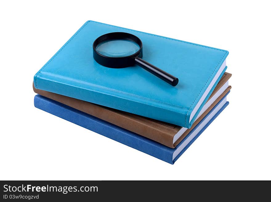 Three books and magnifying lens isolated on white