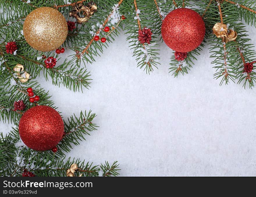 Christmas ornaments with evergreen branches on a white snowy background. Christmas ornaments with evergreen branches on a white snowy background