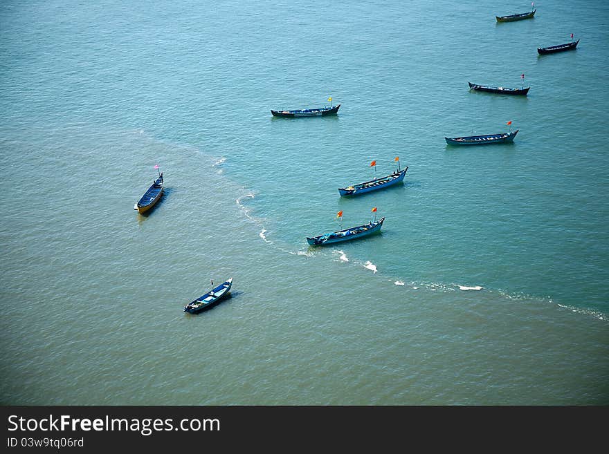 Group of small boats anchored in the blue waters of Arabian sea. murudeshwar Karnataka India. Group of small boats anchored in the blue waters of Arabian sea. murudeshwar Karnataka India