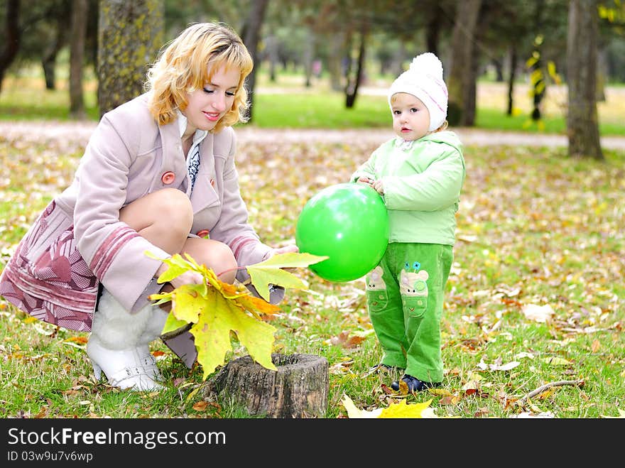 Small beautiful girl in green suit with mother