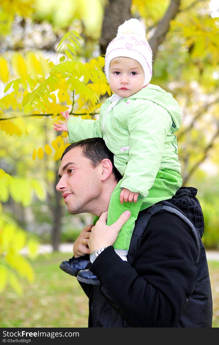 Small beautiful girl in green suit with father