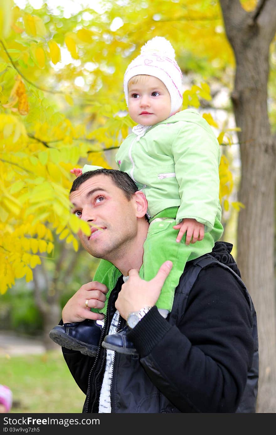 Small beautiful girl in green suit with father