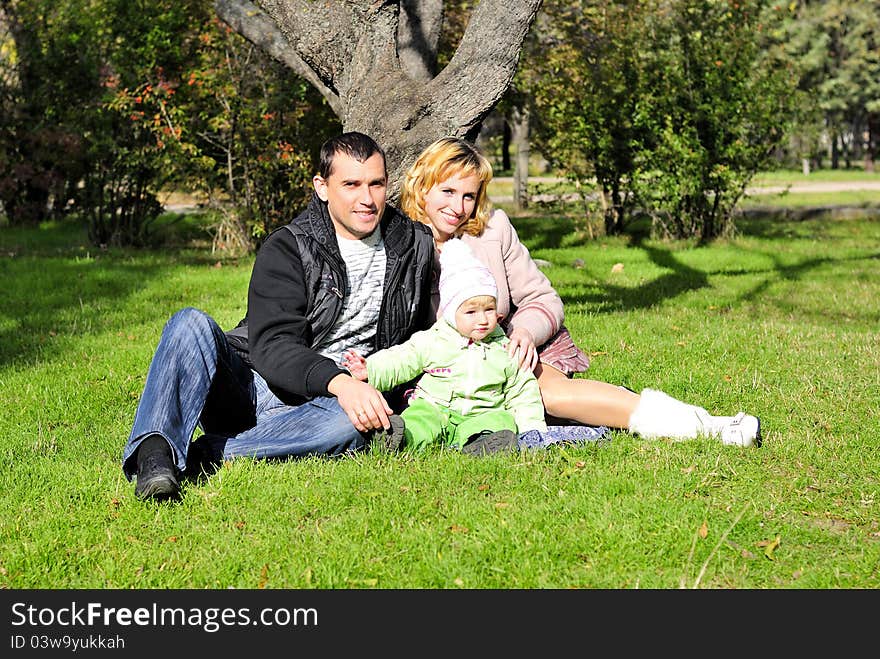 Small beautiful girl with parent on green glade