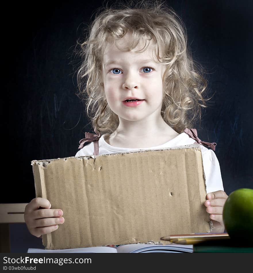 Schoolchild with paper blank in class against blackboard. School concept