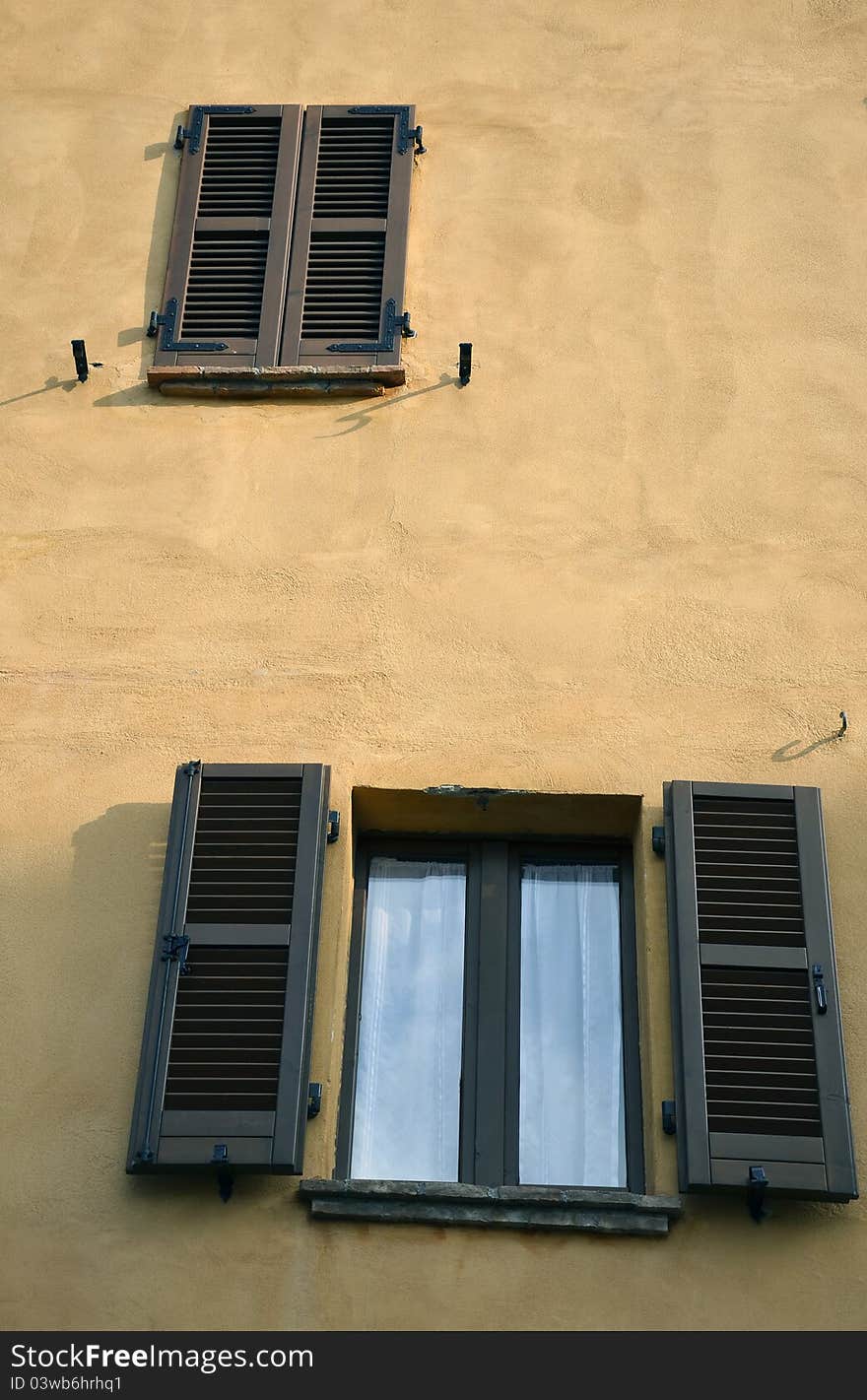 Open and closed window on red wall