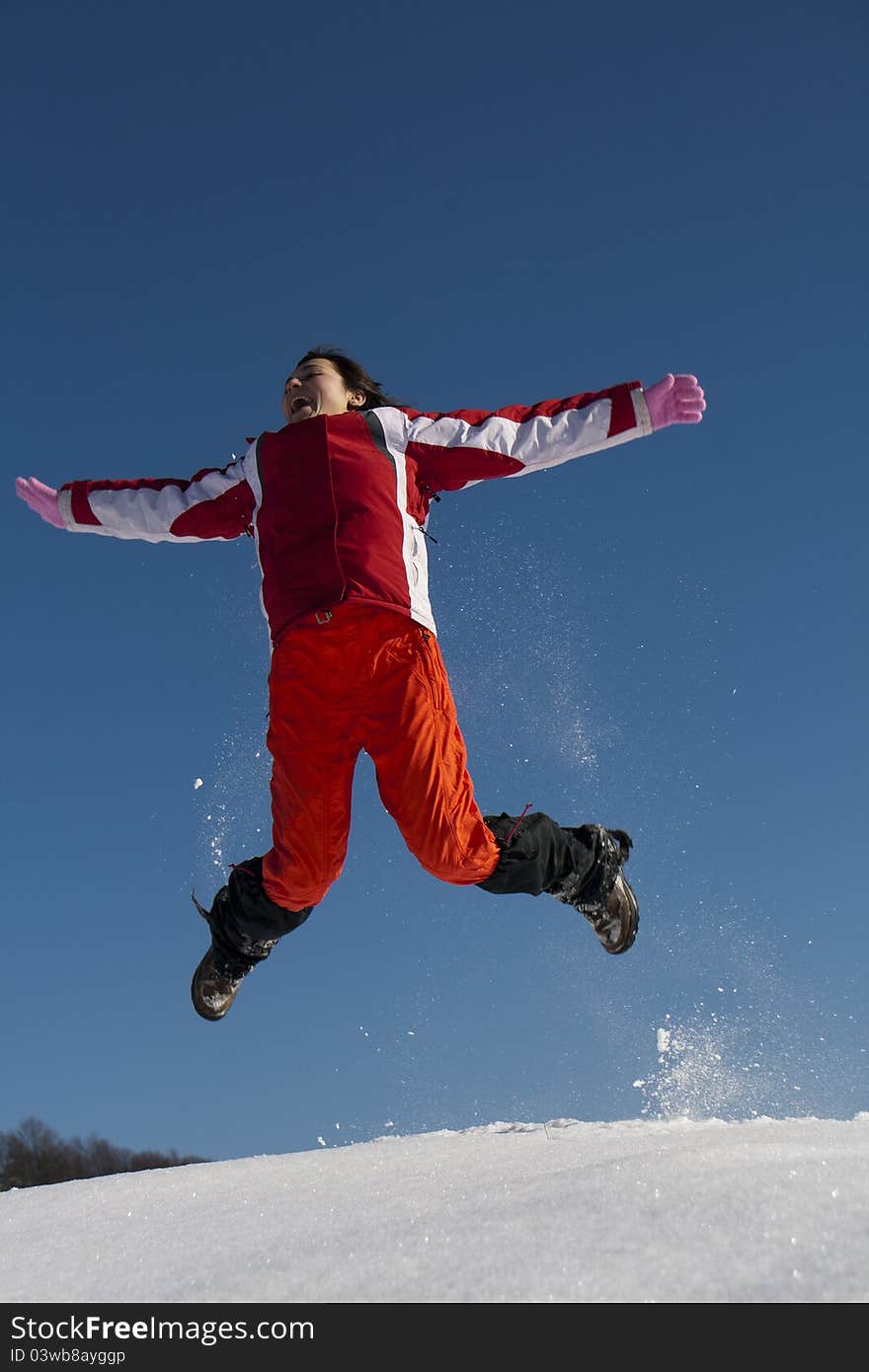 Young Woman Jumping In Snow