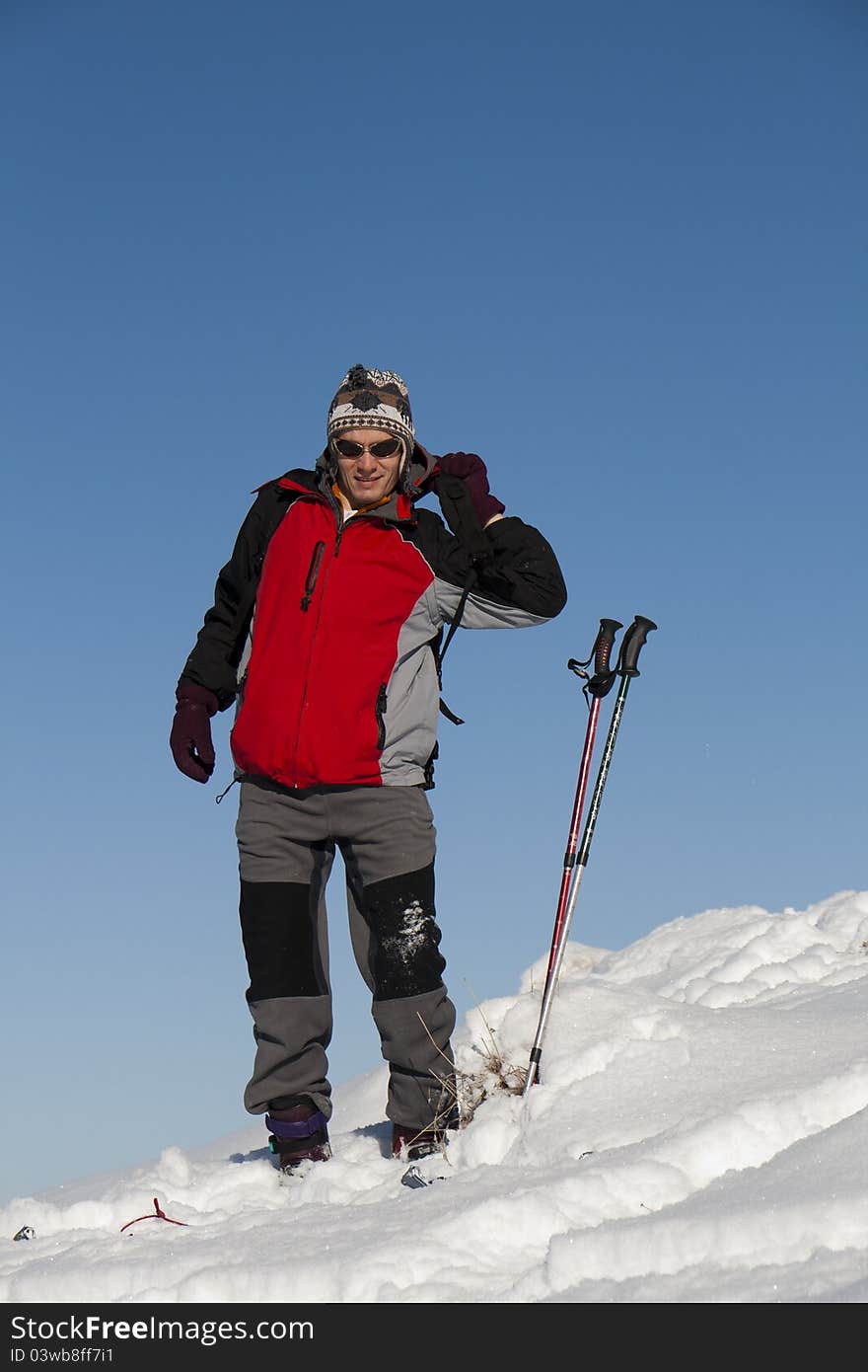 Young man in the snow getting ready for ski. Young man in the snow getting ready for ski