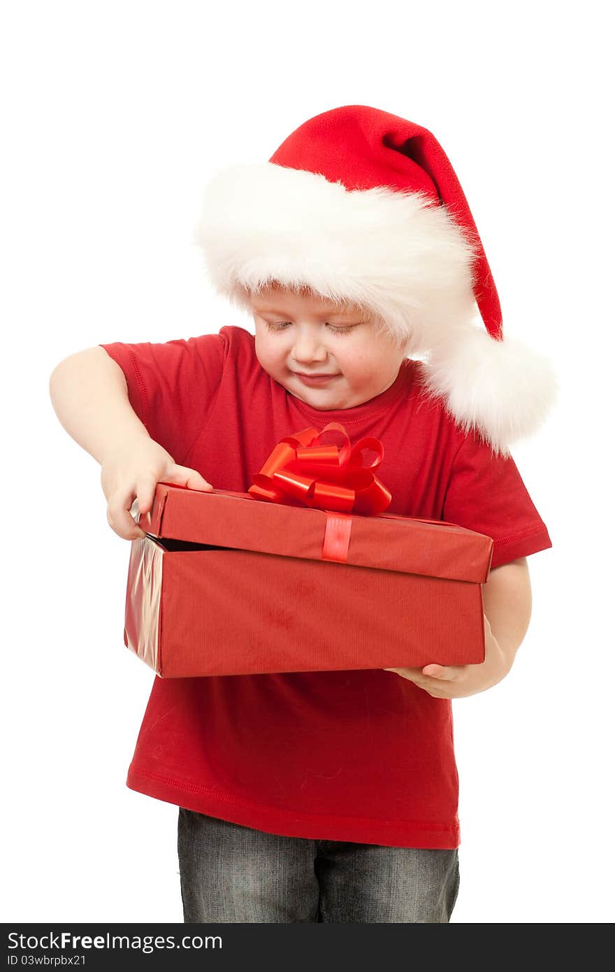 Adorable boy in Santa hat opening christmas gift in red box isolated on white