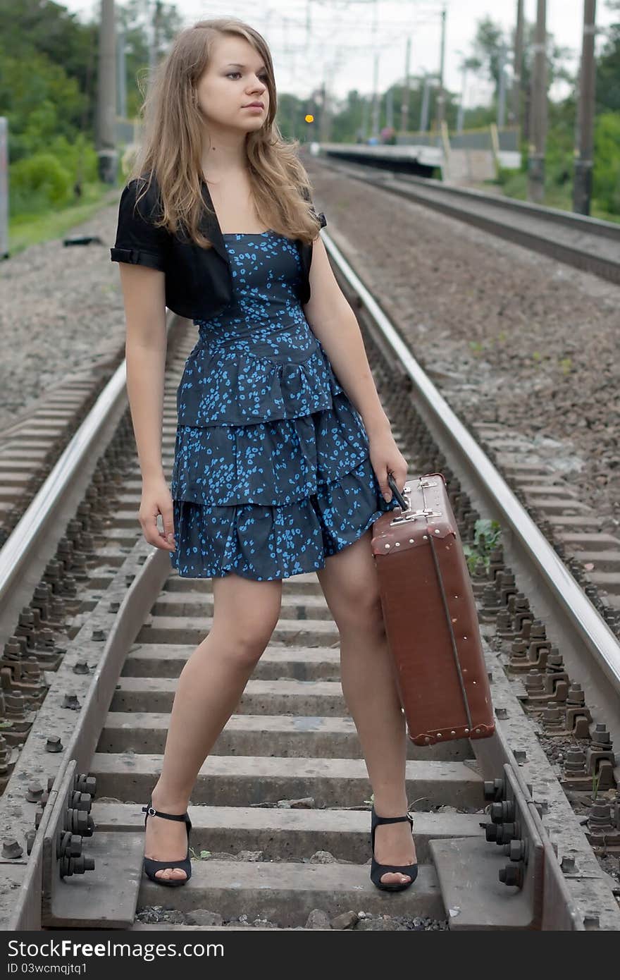 Girl With A Suitcase Standing On The Rails