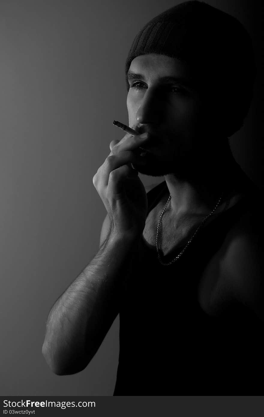 Young man with a cigarette in the dark